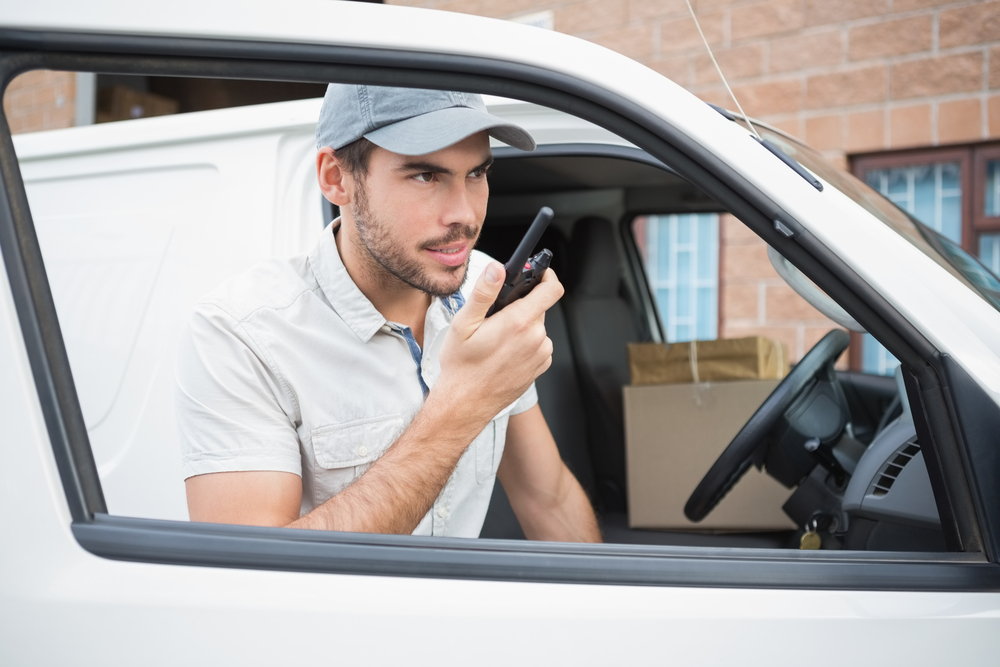 Freight van driver using a radio to contact his office